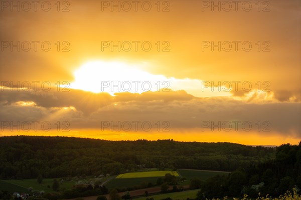 Landscape at sunrise. Beautiful morning landscape with fresh yellow rape fields in spring. Small castle in the yellow fields on a hill. Historic Ronneburg Castle in the middle of nature, Ronneburg, Hesse, Germany, Europe