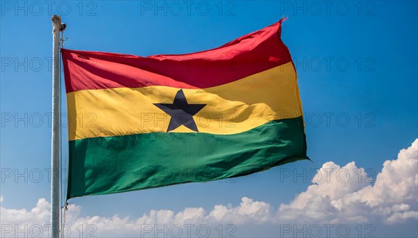 The flag of Ghana flutters in the wind, isolated against a blue sky