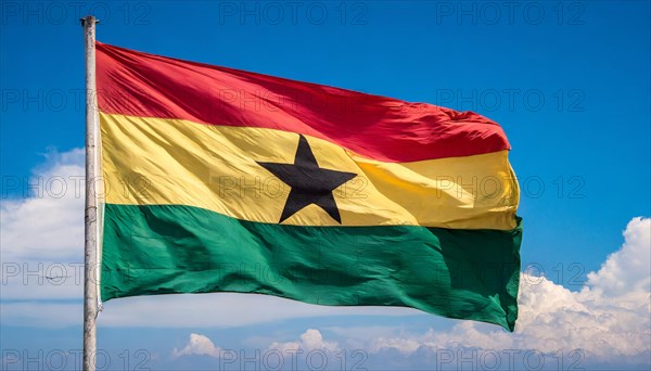 The flag of Ghana flutters in the wind, isolated against a blue sky