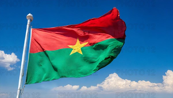 The flag of Burkina Faso flutters in the wind, isolated against the blue sky