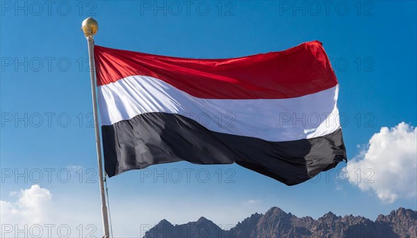 The flag of Yemen, fluttering in the wind, isolated, against the blue sky