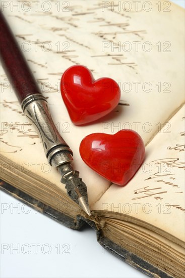 Pen with pen holder and red hearts on diary