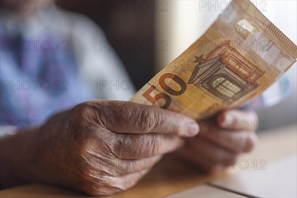 Wrinkled hands of a senior citizen with banknotes at home in her living room, close-up, Cologne, North Rhine-Westphalia, Germany, Europe