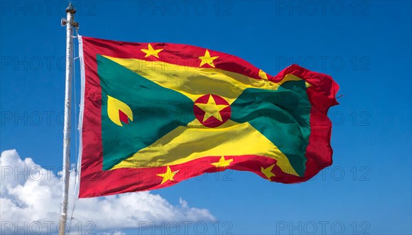 The flag of Grenada, Caribbean, flutters in the wind, isolated, against the blue sky