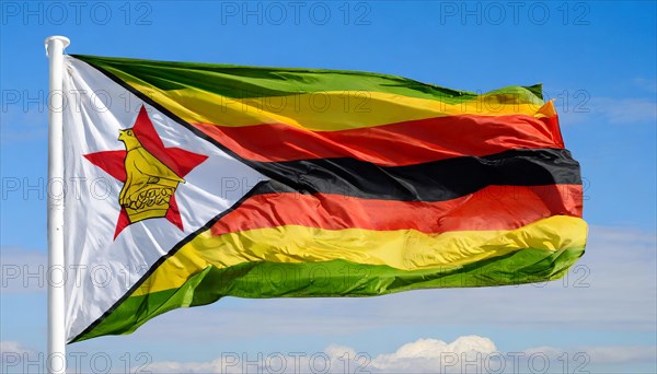 The flag of Zimbabwe, fluttering in the wind, isolated, against the blue sky