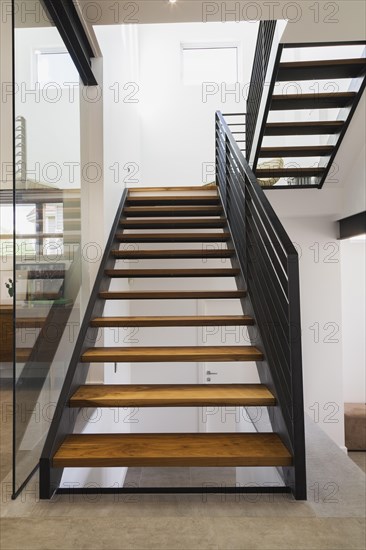 American walnut wood and black powder coated cold rolled steel stairs inside modern cube style home, Quebec, Canada, North America