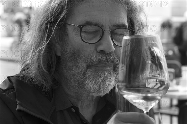 Portrait, Man enjoying a glass of wine with closed eyes, Genoa, Italy, Europe