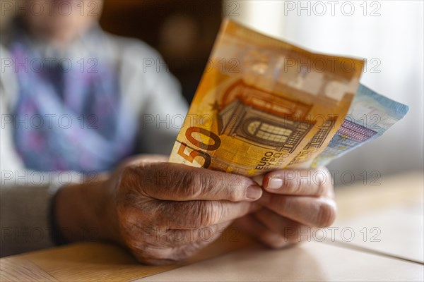 Wrinkled hands of a senior citizen with banknotes at home in her living room, close-up, Cologne, North Rhine-Westphalia, Germany, Europe