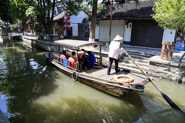 Excursion to Zhujiajiao Water Village, Shanghai, China, Asia, Boatman navigates a tourist boat on an urban river, Asia