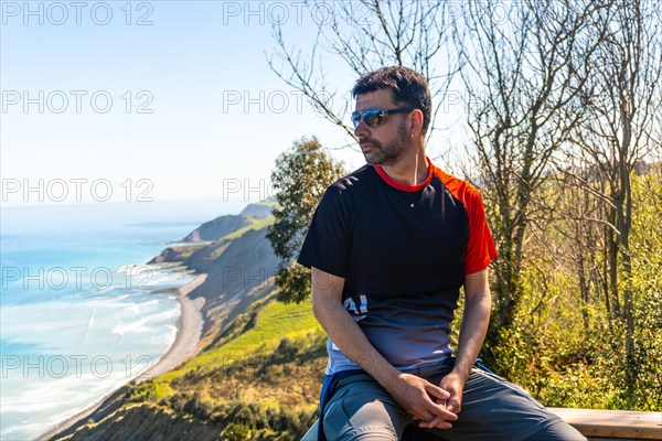 Portrait of a man looking at the beautiful coastal landscape in the flysch of Zumaia, Gipuzkoa. Basque Country