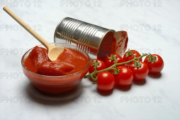 Tinned tomatoes in a bowl, tin can and tomatoes