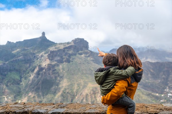 A mother with her son looking at Roque Nublo from a viewpoint. Gran Canaria, Spain, Europe