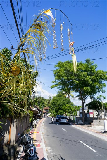 Jewellery artfully woven from palm leaves on bamboo poles for a festival, on a village street in Amed, Karangasem, north-east Bali, Indonesia, Asia