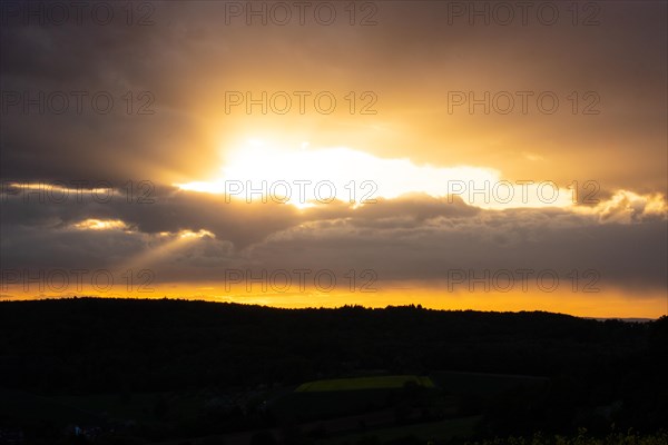 Landscape at sunrise. Beautiful morning landscape with fresh yellow rape fields in spring. Small castle in the yellow fields on a hill. Historic Ronneburg Castle in the middle of nature, Ronneburg, Hesse, Germany, Europe