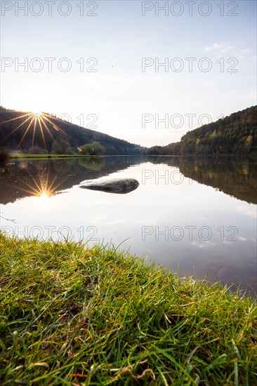 Lake at sunset. Beautiful landscape, taken from the shore of a reservoir. Situated in the middle of the forest and surrounded by nature, the reservoir offers a great atmosphere. Marbach Reservoir, Odenwald, Hesse, Germany, Europe