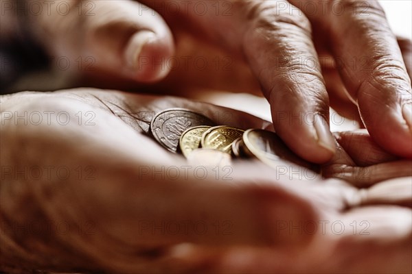 Coin money in the wrinkled hand of a senior citizen, symbolising poverty and poverty in old age, Cologne, North Rhine-Westphalia, Germany, Europe