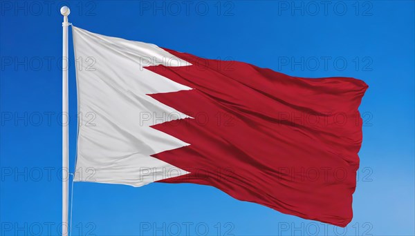The flag of Bahrain flutters in the wind, isolated against a blue sky