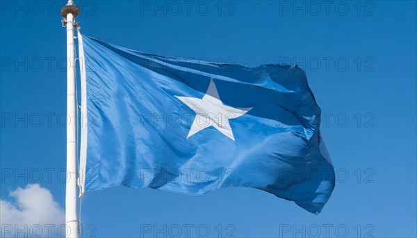 The flag of Somalia, fluttering in the wind, isolated, against the blue sky