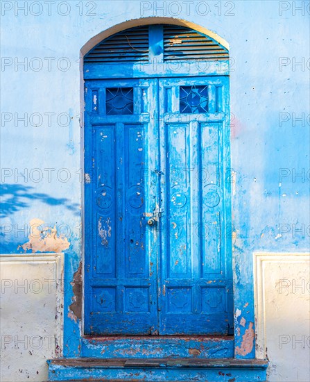 Details of an old blue door. An old blue wooden door of a house