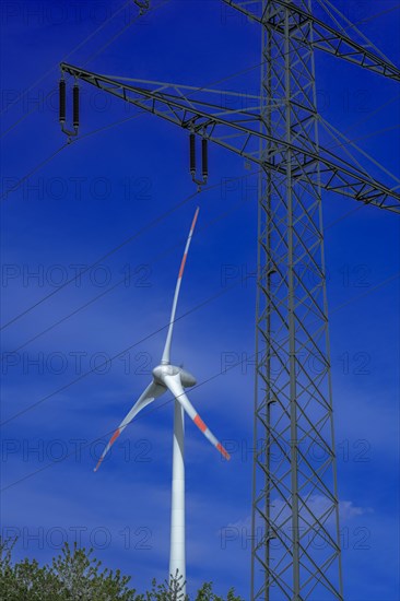 Electricity pylon with high-voltage lines and wind turbine at the Avacon substation Helmstedt, Helmstedt, Lower Saxony, Germany, Europe