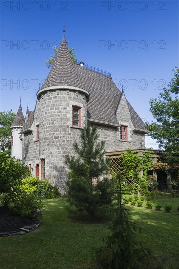 2006 reproduction of a 16th century grey stone and mortar Renaissance castle style residential home facade in summer, Quebec, Canada, North America