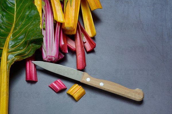 Red and yellow chard, kitchen knife and chopped stems, Beta vulgaris