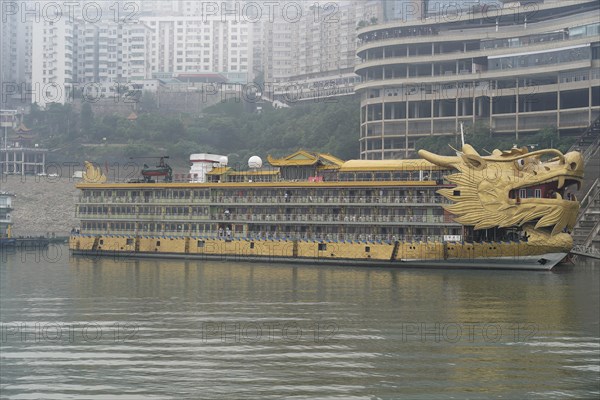 Yichang, Hubei Province, China, Asia, A large ship with a dragon design on an urban riverbank in foggy weather, Asia