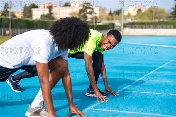 African athletes in starting position to begin running on an athletics track