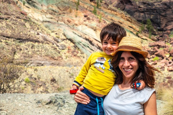 Portrait of mother and son enjoying at the Natural Monument Azulejos de Veneguera or Rainbow Rocks in Mogan, Gran Canaria