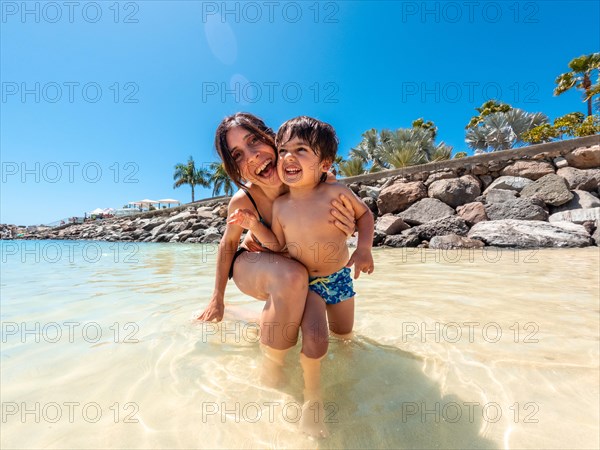 Portrait of a mother and son on vacation on a beach in the Canary Islands. Concept of happy family outdoors. Family vacation on the sea coast