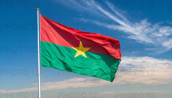 The flag of Burkina Faso flutters in the wind, isolated against the blue sky