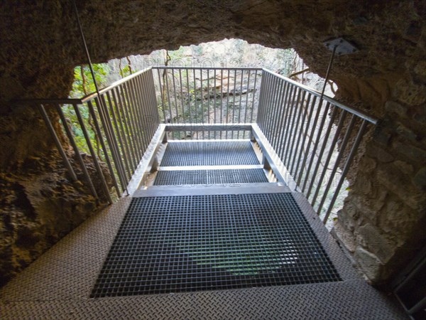 Metal lookout leads through a stone passageway in a cave structure, El Pozo de los Aines, Grisel, Tarazona, Spain, Europe