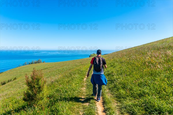 A tourist walking along a path near the Zumaia flysch, Gipuzkoa. Basque Country