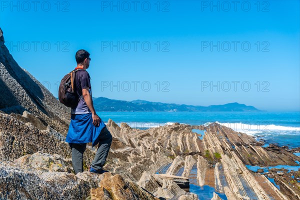 A male hiker in the Flysch Basque Coast geopark in Zumaia, Gipuzkoa