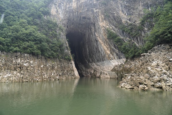 Cruise ship on the Yangtze River, Hubei Province, China, Asia, A cave opens into a rock next to a river with green water, Yichang, Asia