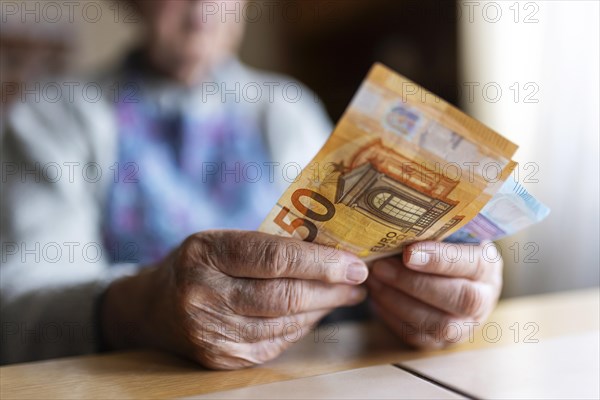 Wrinkled hands of a senior citizen with banknotes at home in her living room, close-up, Cologne, North Rhine-Westphalia, Germany, Europe