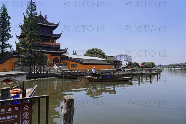 Excursion to Zhujiajiao Water Village, Shanghai, China, Asia, Wooden boat on canal with views of historic architecture, A traditional riverside pagoda with a boat and a tranquil atmosphere, Asia