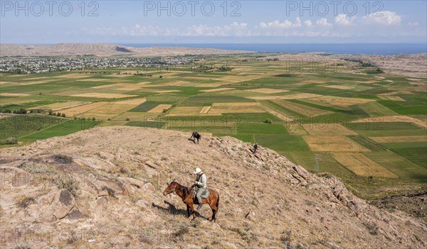 Young man on a horse in the mountains, tourist riding, near Bokonbayevo, Issyk Kul region, Kyrgyzstan, Asia