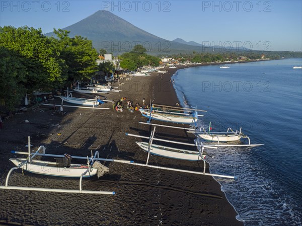 Fishermen loading fish from their outrigger boats in the morning on the black beach of Amed, Amed, Karangasem, Bali, Indonesia, Asia