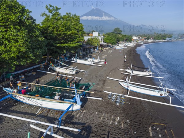 Fishermen loading fish from their outrigger boats in the morning on the black beach of Amed, Amed, Karangasem, Bali, Indonesia, Asia