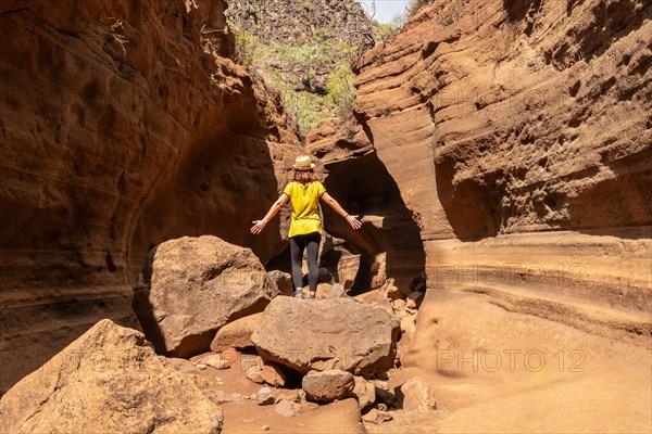 A tourist woman with hat in the limestone canyon Barranco de las Vacas in Gran Canaria, Canary Islands