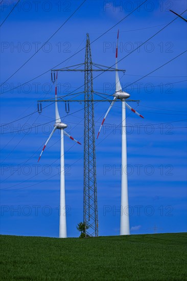 Power pylon with high-voltage lines and wind turbines at the Avacon substation Helmstedt, Helmstedt, Lower Saxony, Germany, Europe