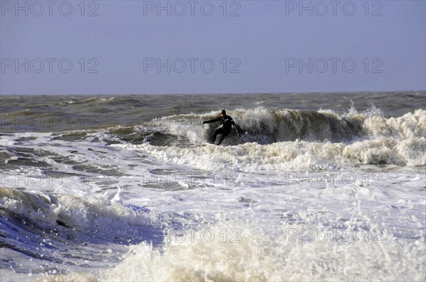 Sylt, North Frisian Island, Schleswig-Holstein, A surfer on a wave in the sea, surrounded by foam, doing sports, Sylt, North Frisian Island, Schleswig-Holstein, Germany, Europe