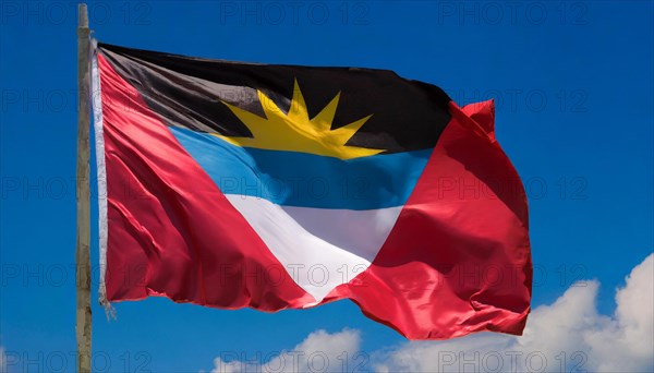 The flag of Antigua flutters in the wind, isolated against the blue sky