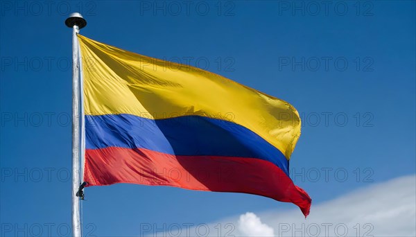 The flag of Colombia flutters in the wind, isolated against a blue sky