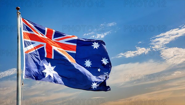 The flag of Australia flutters in the wind, isolated against a blue sky