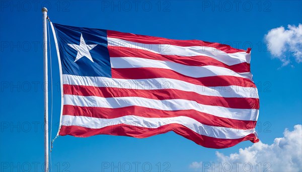 The flag of Liberia, fluttering in the wind, isolated, against the blue sky