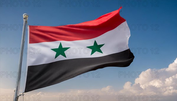 The flag of Syria flutters in the wind, isolated against a blue sky