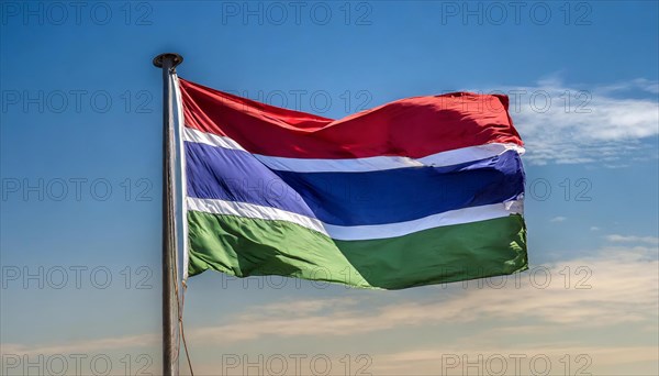 The flag of Gambia, fluttering in the wind, isolated, against the blue sky