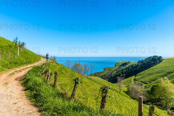 Trail and a beautiful landscape with a man on the way up to the flysch of Zumaia, Gipuzkoa. Basque Country